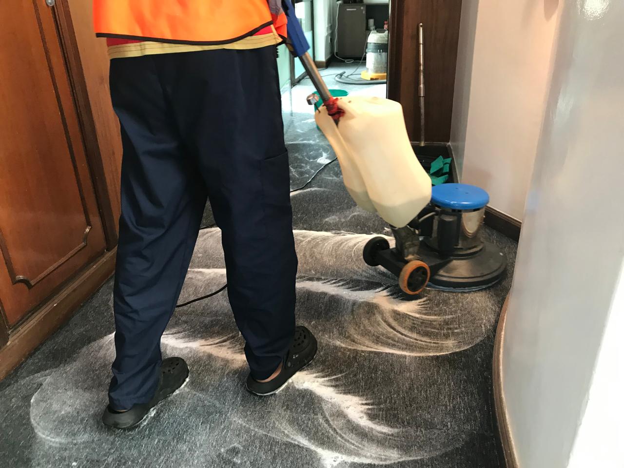 An OnyxHawk crew member shampooing an office carpet with a rotary scrubber